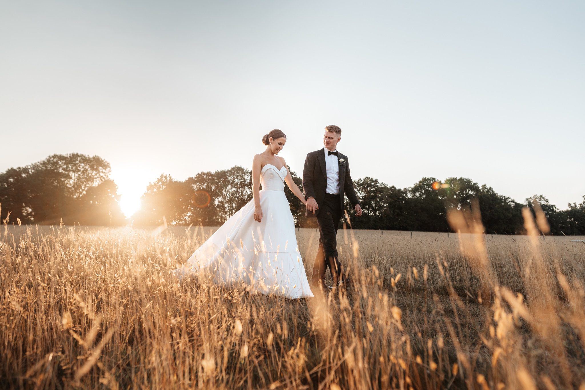 bride and groom blissfully walking through the beautiful fields after their silchester farm wedding