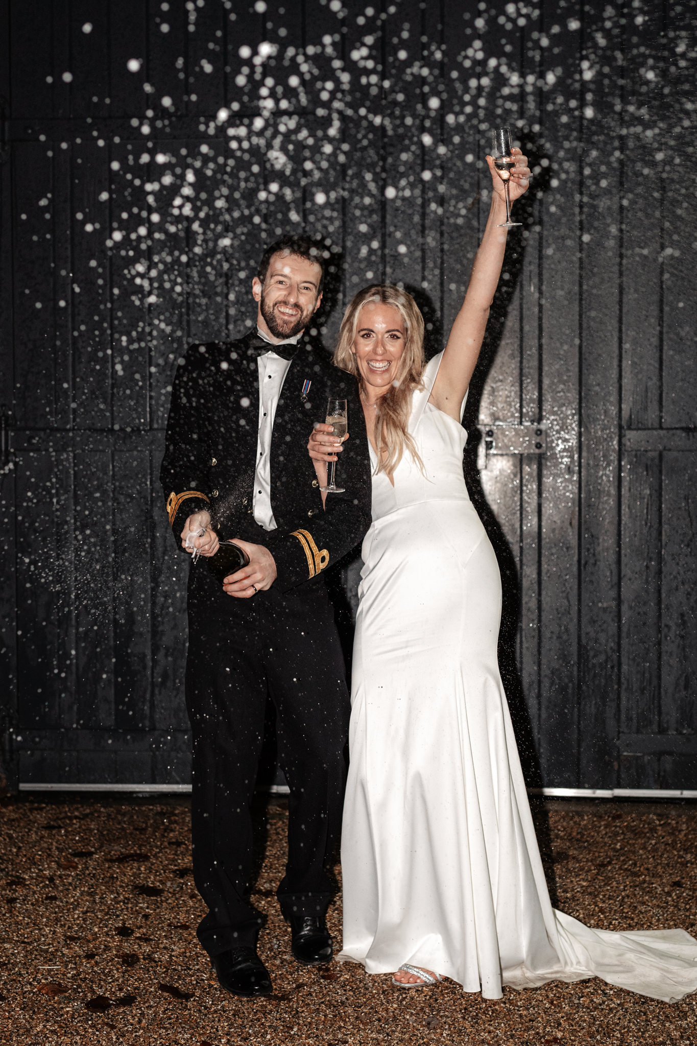 bride and groom evening portraits while popping the bubbly during their wedding at bury court barn
