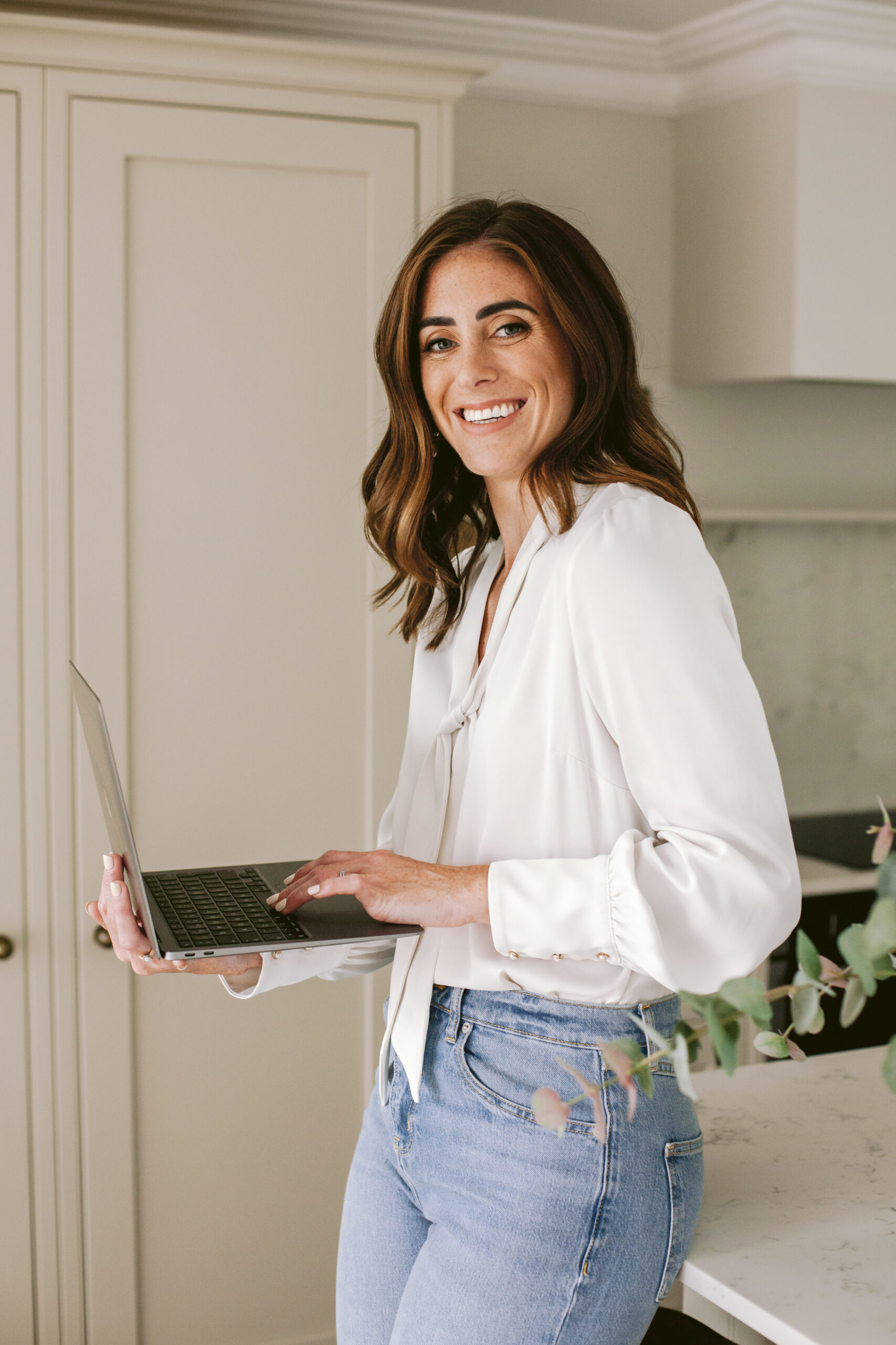 chloe caldwell photography, a mentor for photographers, holding her laptop and smiling