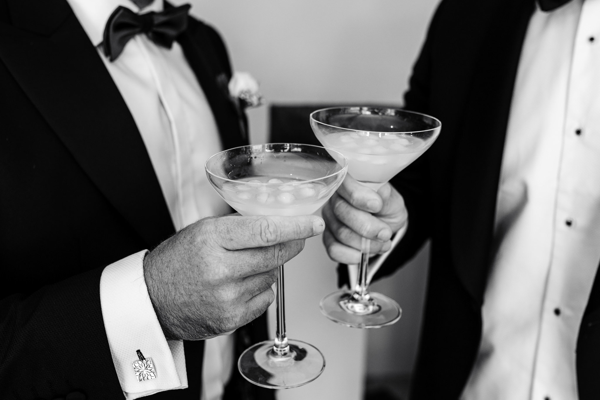 close up of two martinis being held at a luxury black tie wedding