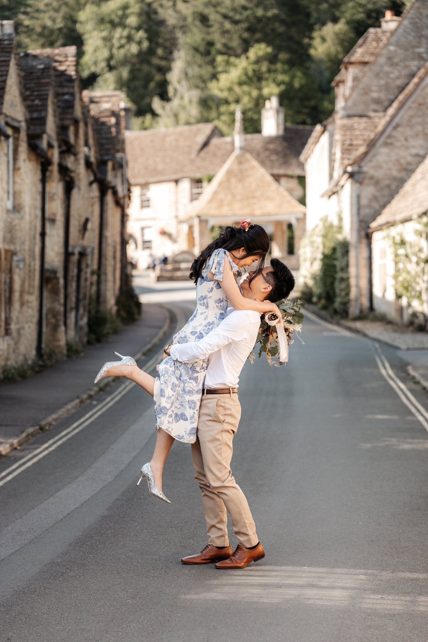 couple embracing during their engagement photography session in a small town in the cotswolds