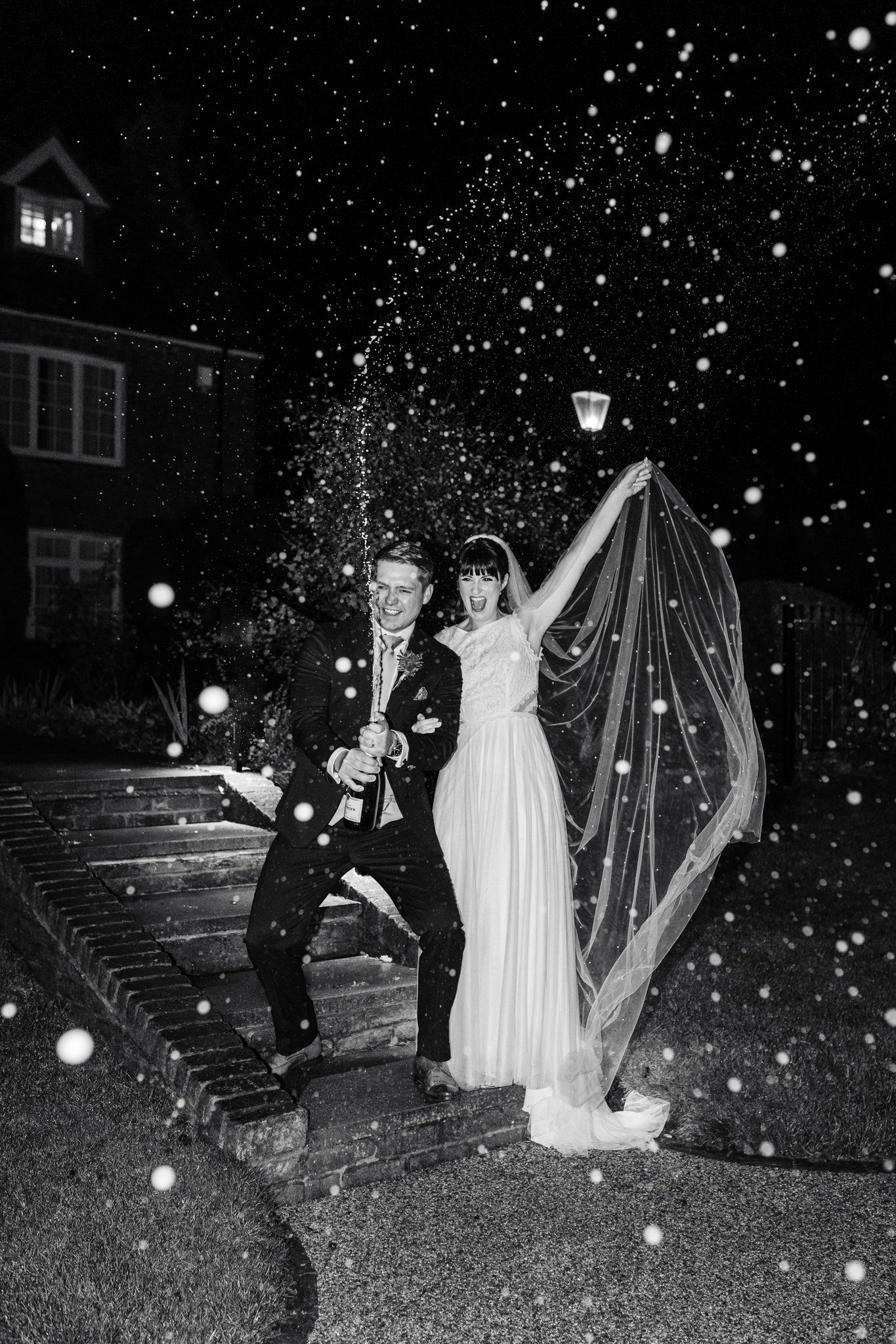 Champagne spray at wedding in black and white