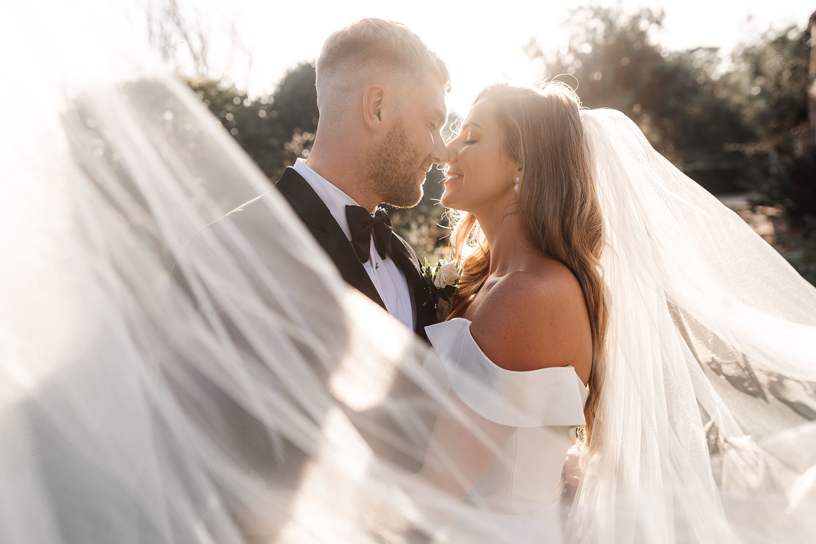 bride and groom romantic elegant veil photo at sunset